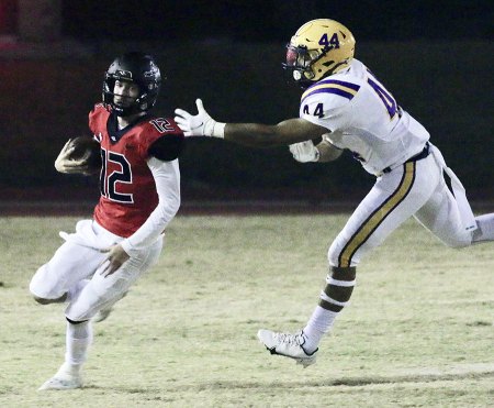 Lemoore's Miguel Rodriguez seeks to take down Hanford's quarterback, Cayden Muir in Friday night's game at Hanford High School.